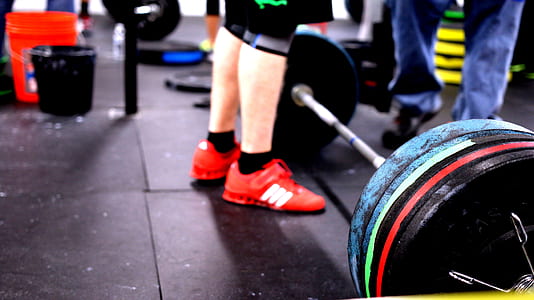 person standing in front of barbell thumbnail
