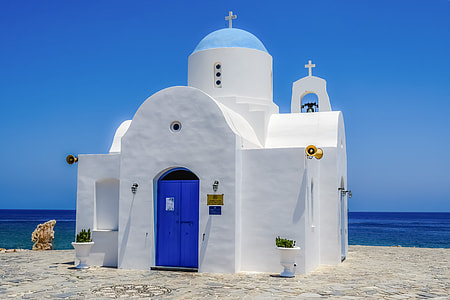 white and blue painted church near body of water thumbnail