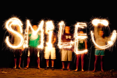 people holding yellow LED light and forming SMILE words thumbnail