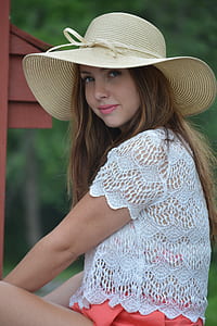 woman wearing beige sun hat and white knit top thumbnail
