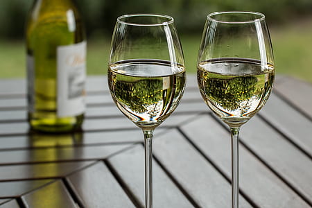 two clear wine glasses on brown wooden table thumbnail