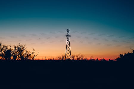 silhouette of electric tower during golden hour thumbnail