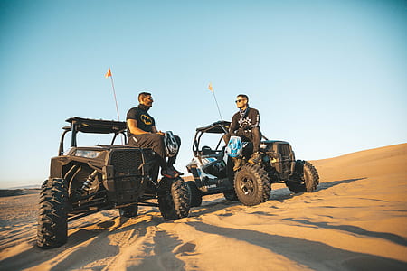 two men sitting on UTV under blue sky during daytime thumbnail