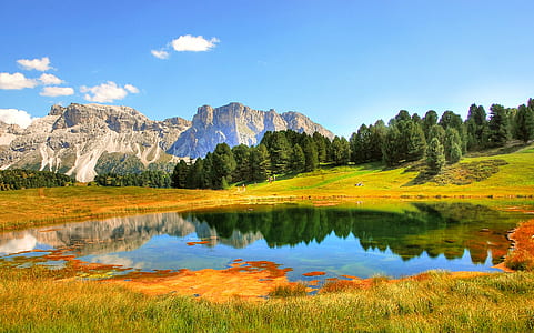 landscape photography of lake surrounded by mountains and plants thumbnail