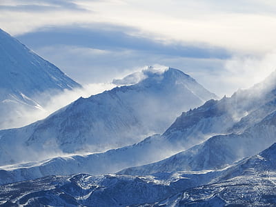 mountain covered in snow under cloudy sky thumbnail