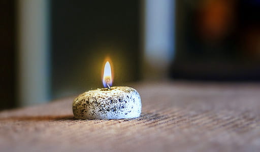 lighted candle on brown cloth thumbnail