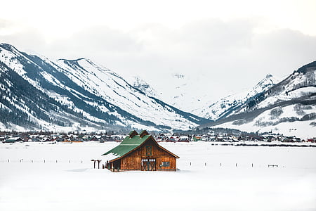 bungalow house on snow near snow covered mountains during daytime thumbnail