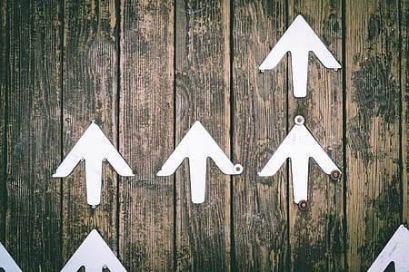 arrow sign on brown wooden board thumbnail