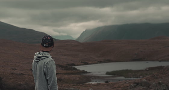man in gray hooded jacket and black and brown fitted cap thumbnail