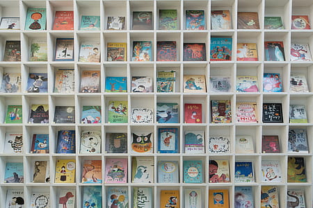 assorted-title books on brown wooden cube organizer thumbnail