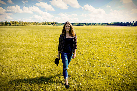woman wearing black shirt and gray cardigan walking on the green grass field thumbnail