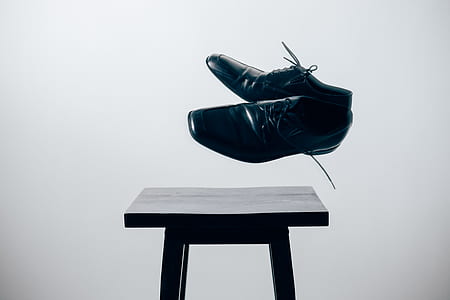 pair of black leather shoes and brown wooden stool thumbnail