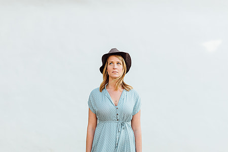 woman wearing teal half-button cap sleeve dress and black hat thumbnail