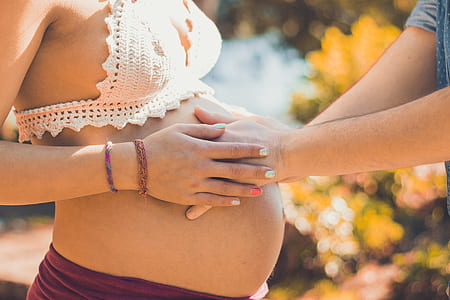 man holding womb of a pregnat woman during daytime thumbnail