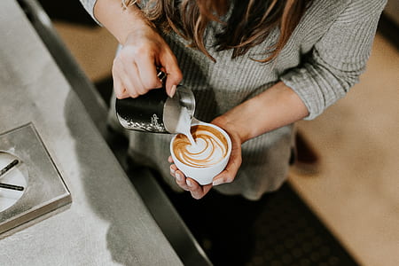 person pouring cream in white ceramic teacup thumbnail
