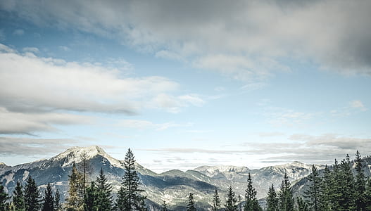 high-angle photography of snow covered mountain range under white clouded blue sky during daytime thumbnail