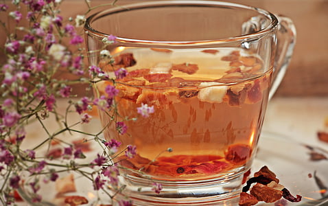 clear glass teacup filled with orange liquid in closeup photo thumbnail