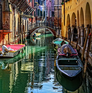 black and white boat on body of water near buildings during daytime thumbnail