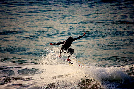 person wearing black wet suit performing surfboarding on blue body of water during daytime thumbnail