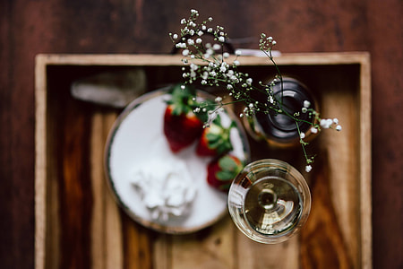 Strawberries with cream and glass of white wine on wooden tray thumbnail