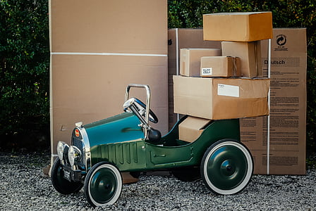 classic green car loaded with brown cardboard boxes thumbnail