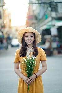 Selective Focus Photography Of Woman Holding Flowers thumbnail