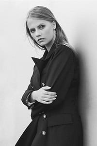 woman in black coat leaning on wall thumbnail