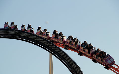 person riding roller coaster under gray sky during daytime thumbnail