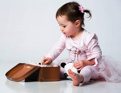 young girl wearing tutu dress while holding leather case thumbnail
