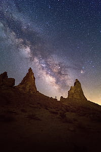 landscape photography of two mountain rock formation with ocean of stars as background thumbnail