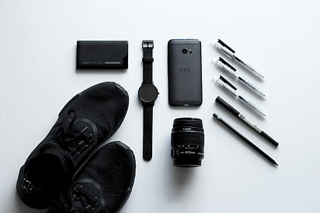 flat lay photography round black analog watch, HTC Android smartphone, and telephoto lens thumbnail