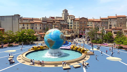 people in park with blue globe fountain at daytime thumbnail