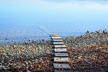 gray pavement near body of water taken during daytime thumbnail