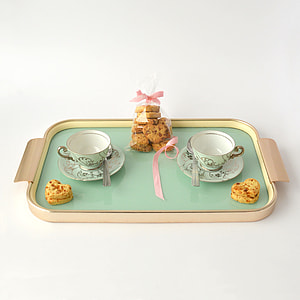 two green ceramic teacup on saucers with baked cookies thumbnail