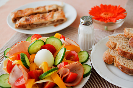 salt shaker near plate of salad and wheat breads thumbnail
