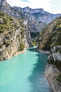 calm body of water surrounded by rock mountain thumbnail