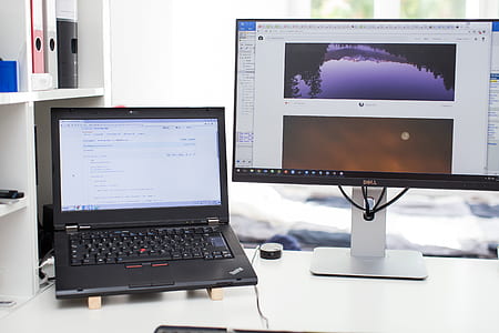 black Lenovo laptop beside monitor thumbnail