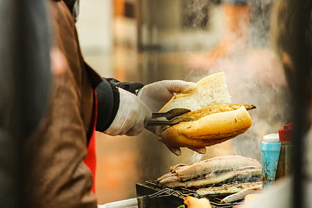 Person Putting Grilled Food in Sliced Bread thumbnail