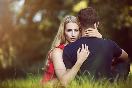 man and woman both sits on green grass field at daytime thumbnail
