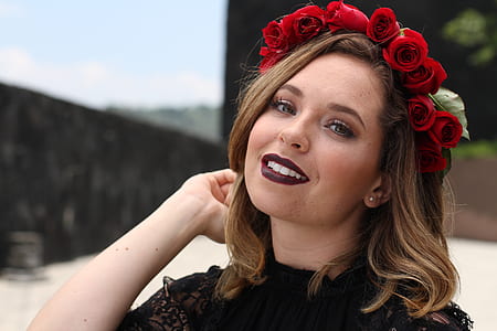 woman wearing rose head dress holding her hair thumbnail