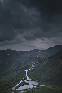 landscape photography of house beside lake under heavy clouds thumbnail