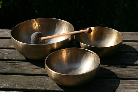 three brass singing bowls on table thumbnail