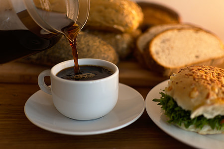 white ceramic teacup on saucer near bread thumbnail