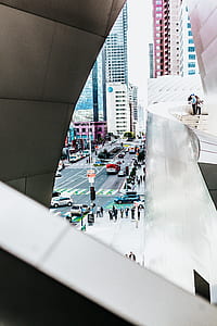 three people standing near building stairs overlooking crowded street with vehicles thumbnail
