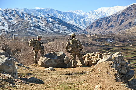 two soldiers on rocky ground during daytime thumbnail