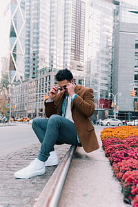 man sitting on floor while holding sunglasses thumbnail