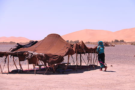 woman in blue dress walks through the tent during daytime thumbnail