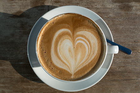 white teacup and saucer on brown surface thumbnail