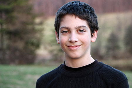 boy wearing black sweater smiling for photo thumbnail