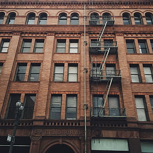 photography of brown concrete building with emergency stairs at daytime thumbnail